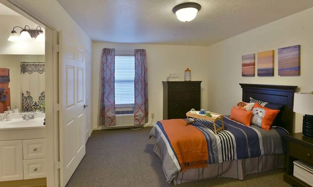A cozy bedroom with a single bed, dresser, and decorative accents.
