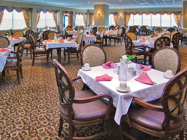 An elegant dining room with tables set for a formal meal.