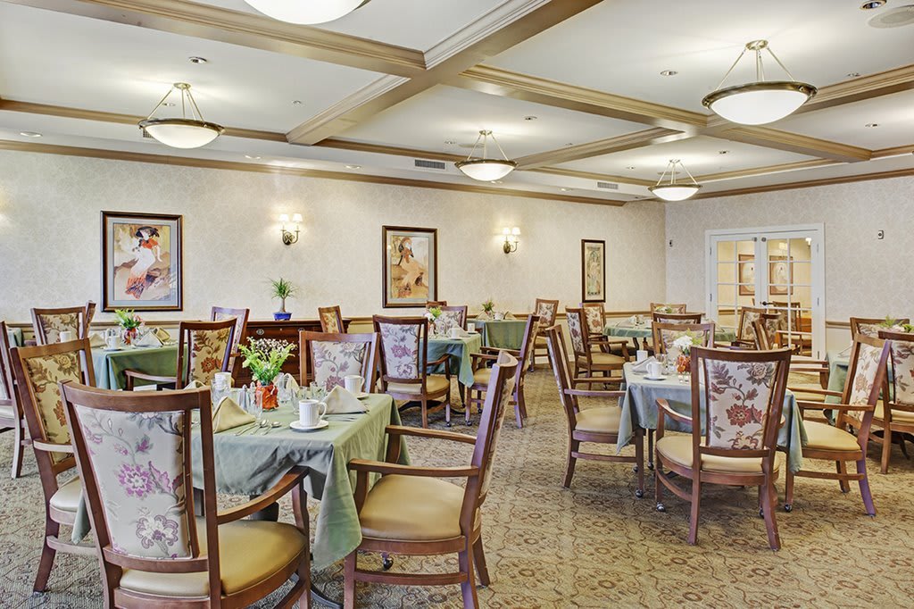 An elegantly decorated dining room with set tables and comfortable seating.