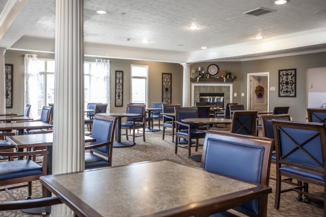 A spacious and modern dining area with neatly arranged tables and chairs, featuring decorative elements and bright lighting.