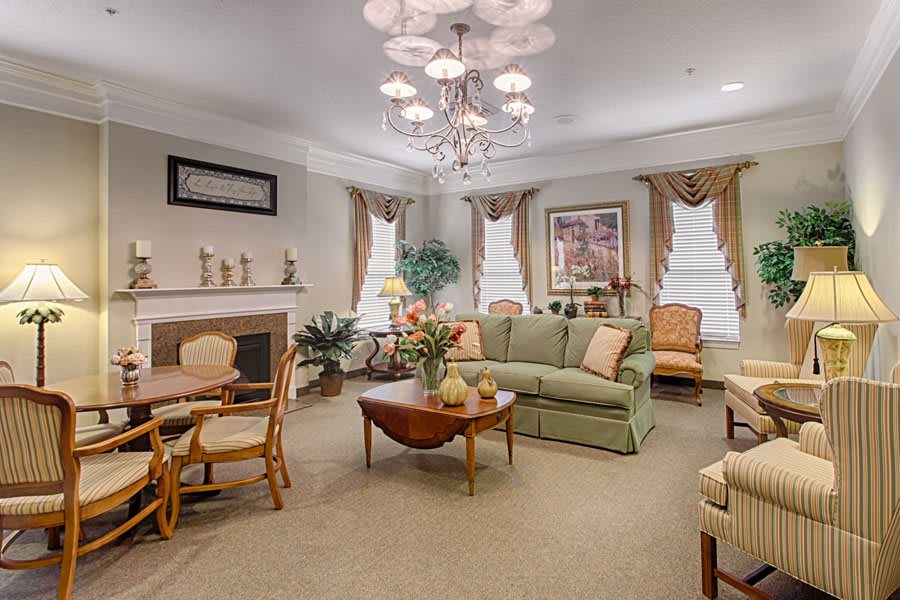A well-furnished living room with a sofa, table, and chandelier.