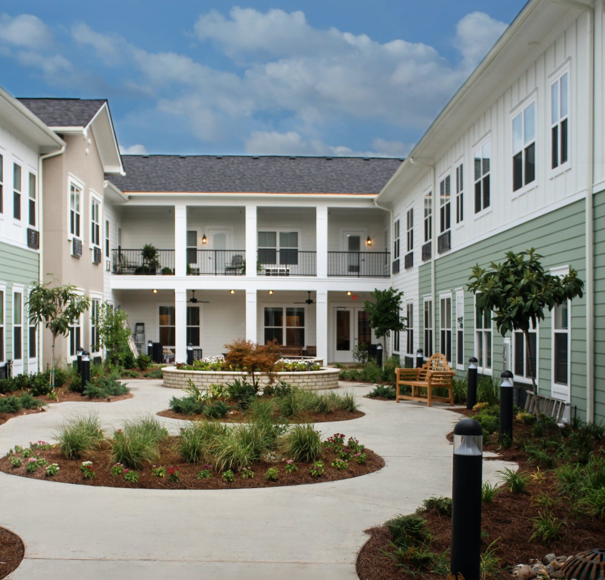 A courtyard view of a modern residential building with well-maintained landscaping.