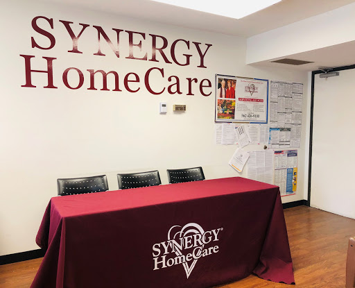 A welcoming reception area of Synergy HomeCare featuring a branded table and seating.