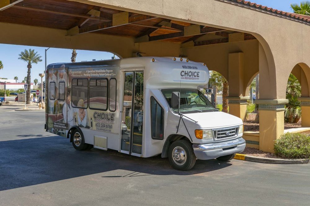 A hotel shuttle bus parked under a covered area.