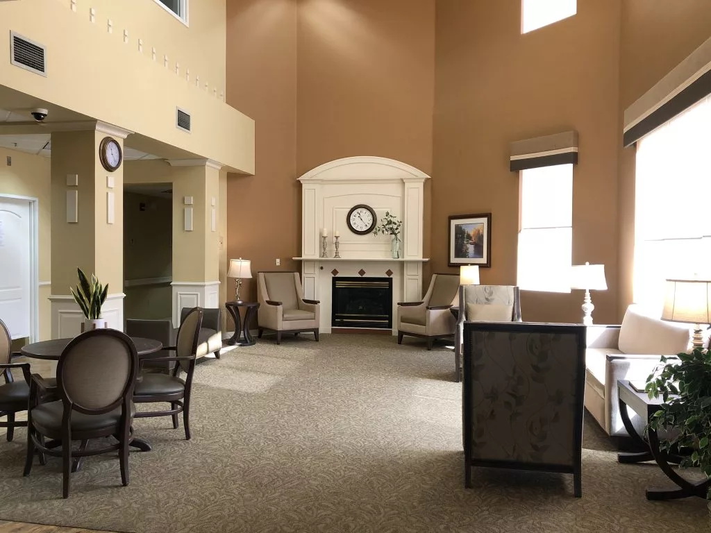 A cozy living room with comfortable seating and a fireplace, basked in natural light.