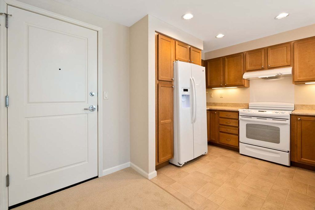 A modern kitchen with white appliances and wooden cabinets.