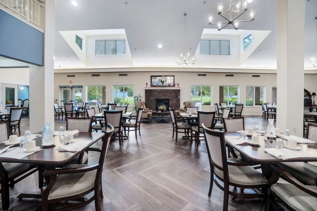 A spacious and elegantly designed dining area with modern furnishings and a central fireplace.