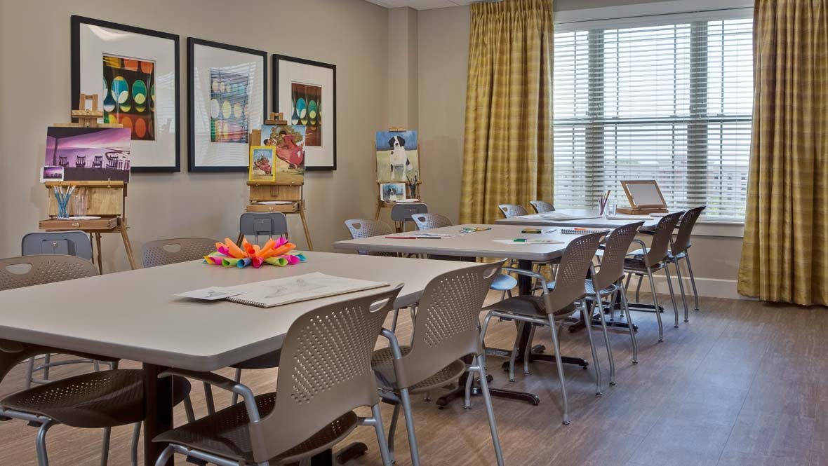 A well-organized classroom designed for kids' art activities, featuring tables with craft materials and a bright interior.