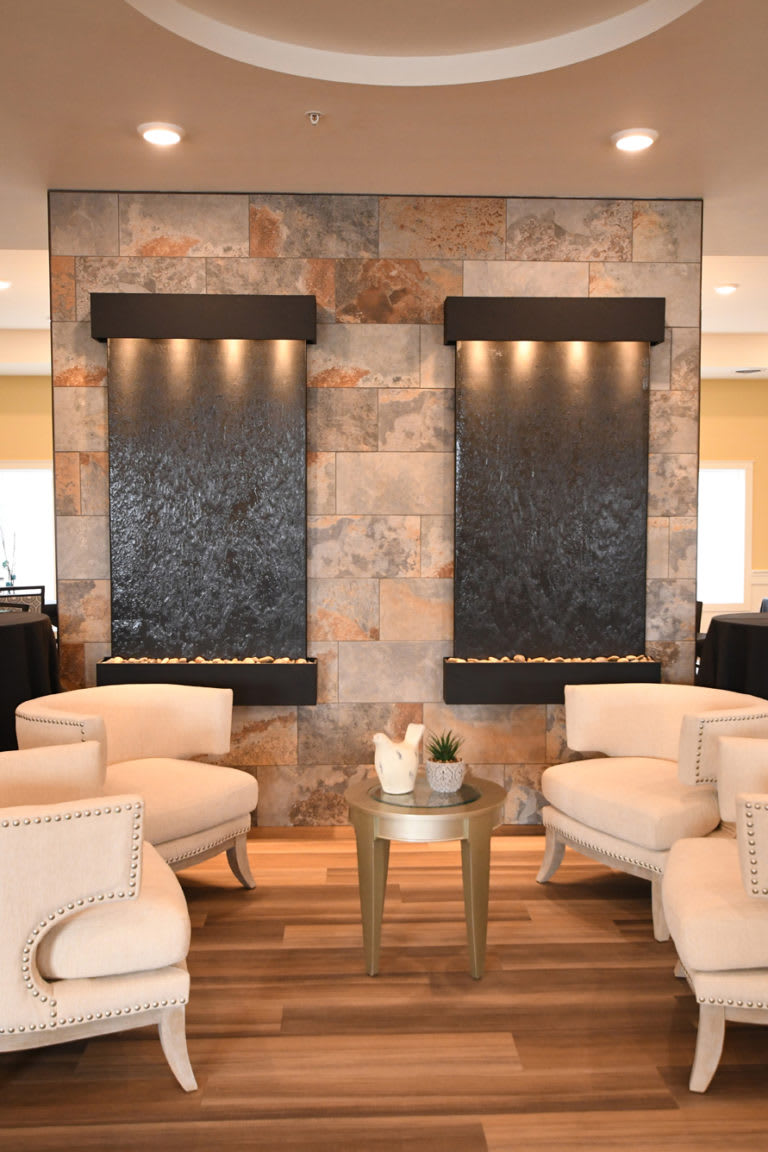 A modern lounge area with comfortable seating and decorative water features.