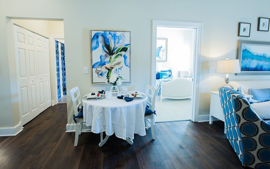 A cozy dining area with a round table, surrounded by chairs and adorned with artistic decor.