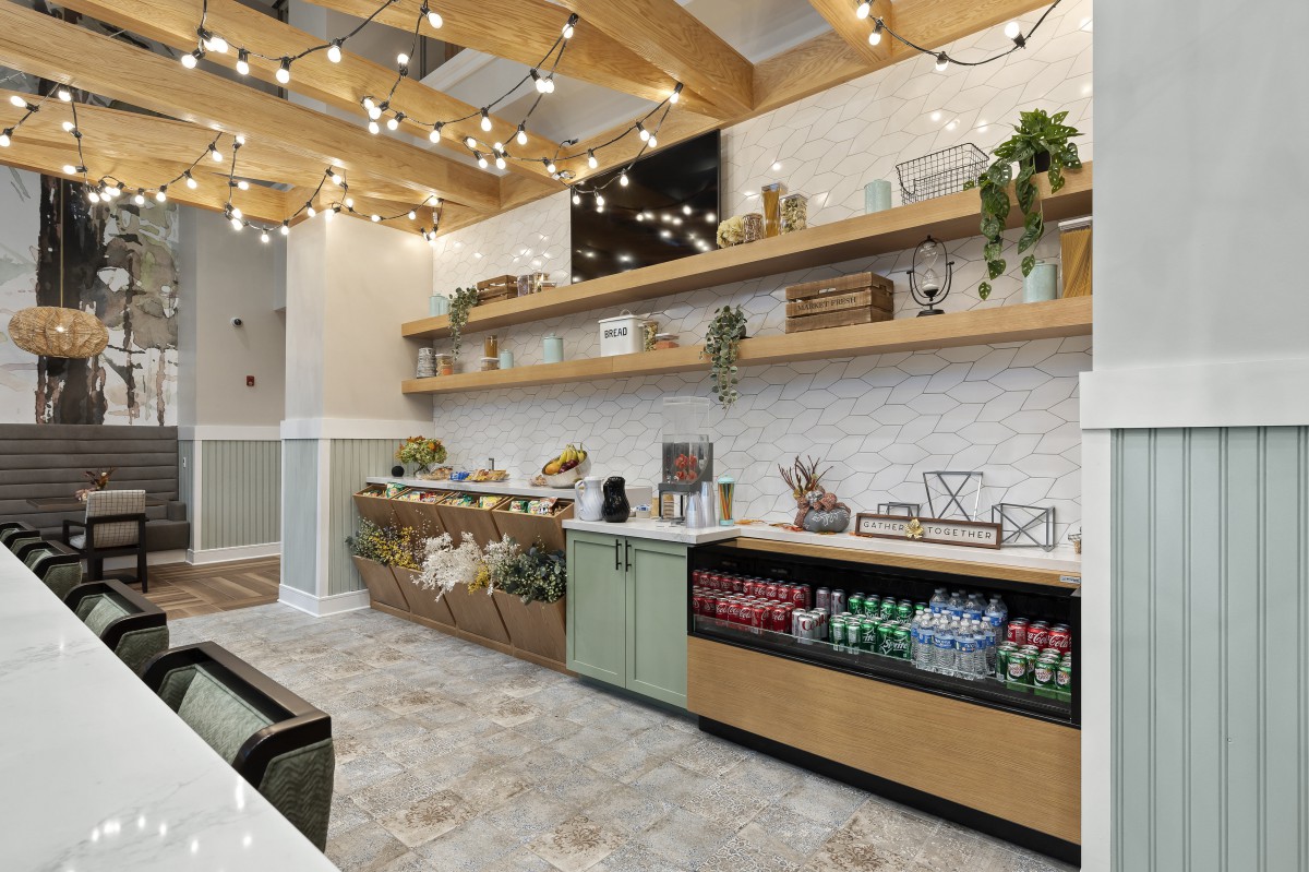 A stylish coffee station with snacks and beverages, featuring modern decor and warm lighting.