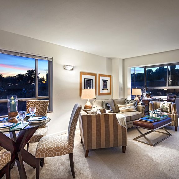 A cozy, modern living and dining area with stylish furniture and large windows.