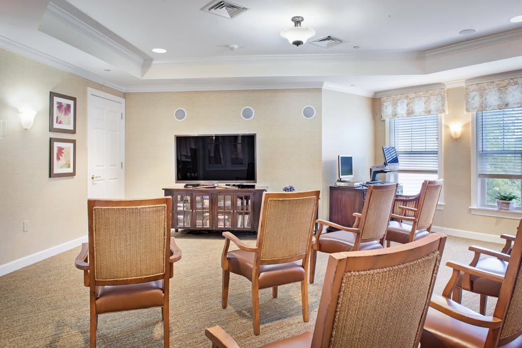A community room with chairs arranged in front of a television.