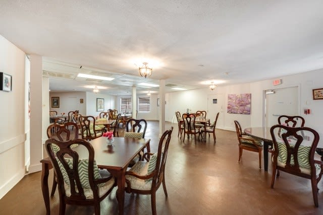 An empty dining room with multiple tables and chairs arranged neatly.