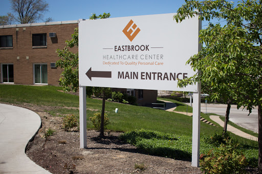 A sign directing visitors to the main entrance of Eastbrook Healthcare Center.