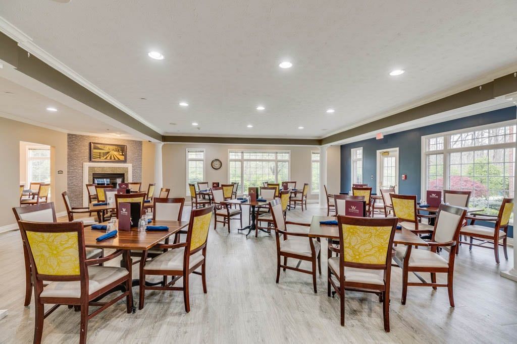 A spacious and well-lit dining area with multiple tables and chairs arranged neatly.