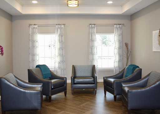 A modern living room setup featuring comfortable chairs and ample natural light.