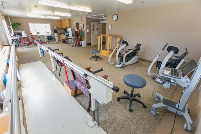 A rehabilitation room equipped with various exercise machines and tools for physical therapy.