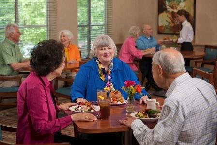 A group of seniors enjoying a meal together in a communal dining area.