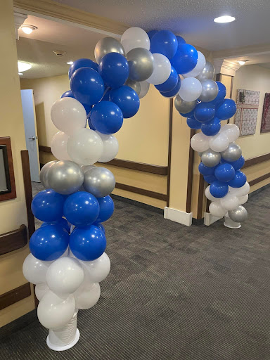 A beautifully arranged balloon arch in blue, silver, and white, perfect for enhancing the ambiance of any celebration.