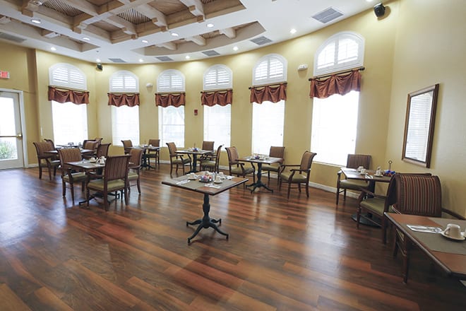 A spacious dining room with elegant furnishings and large windows.