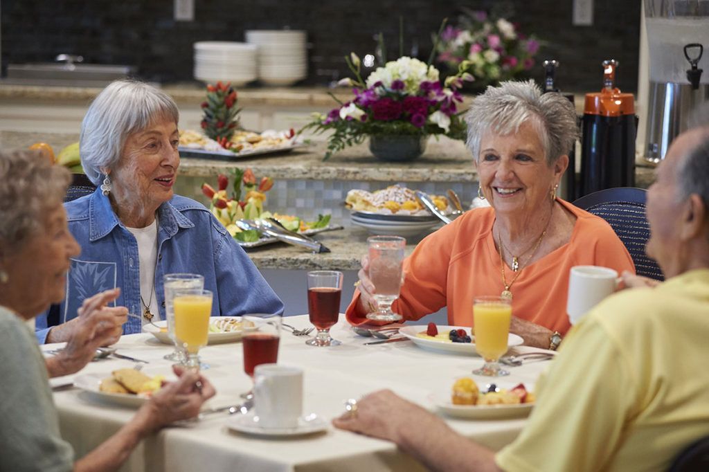 A group of seniors enjoying breakfast together, sharing conversation and laughter.