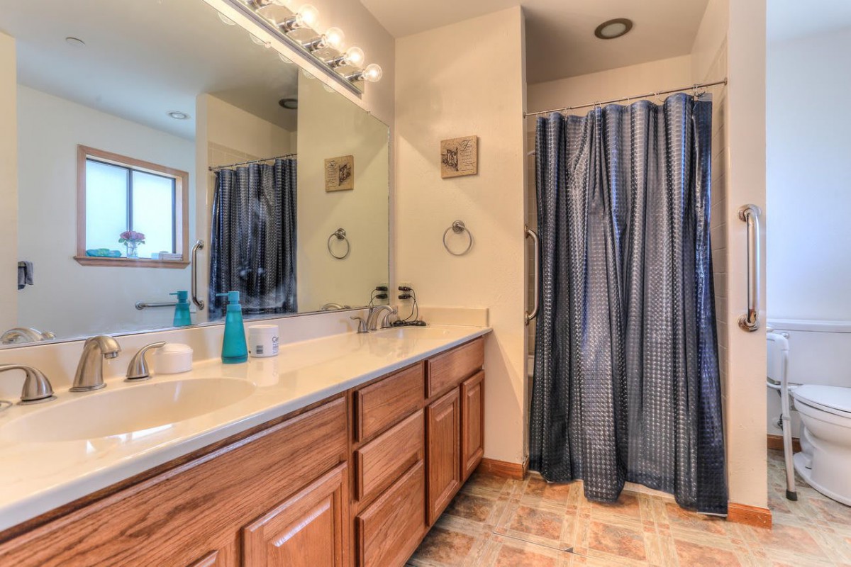 A cozy bathroom with wooden cabinets and a striped shower curtain.