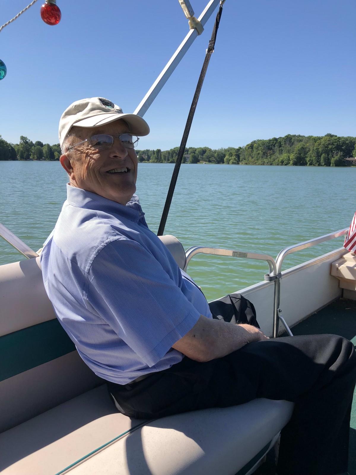 A man relaxing on a boat on a sunny day at the lake.