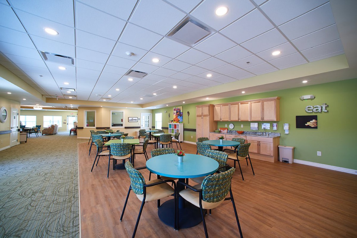 A modern dining area with round tables and colorful chairs in a bright, open space.