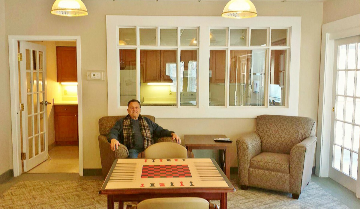A person sitting in a cozy living room with comfortable seating and a table.
