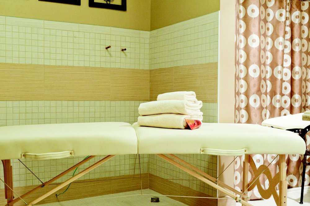 A serene spa room featuring a massage table with neatly folded towels.