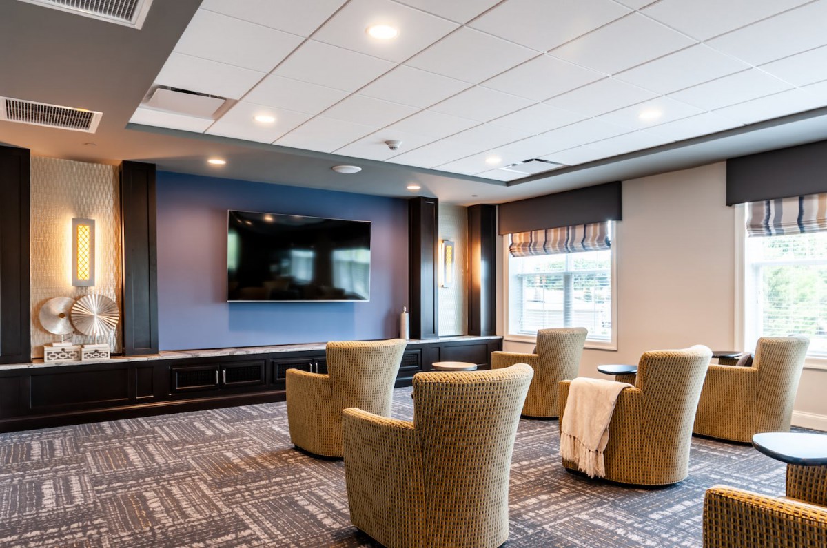 A modern living room with comfortable chairs and a large television.