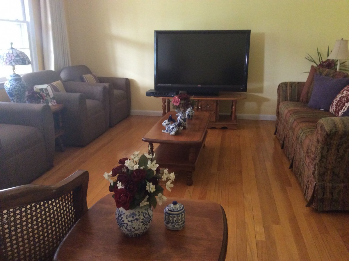 A cozy living room with a large television and comfortable seating.