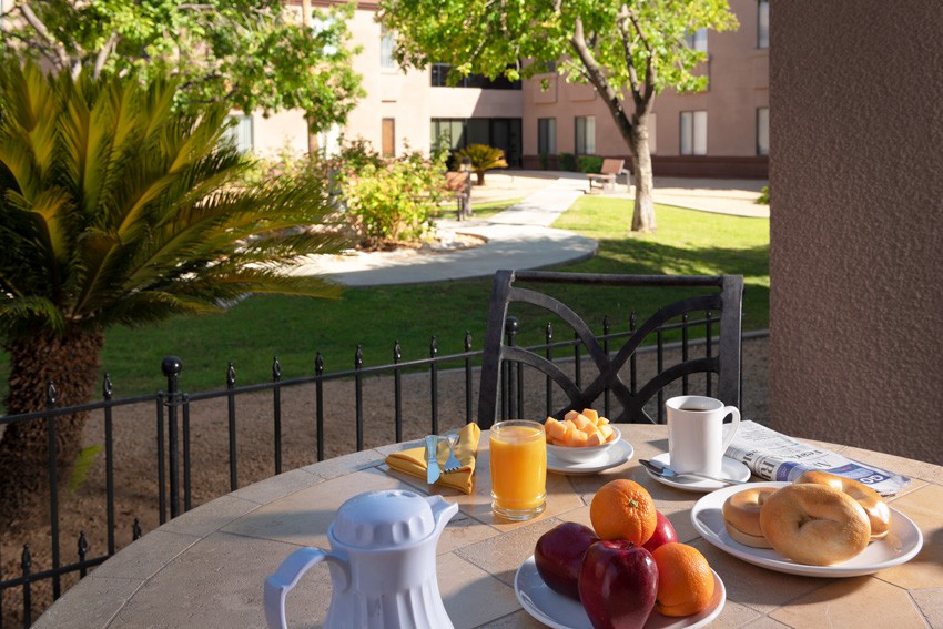A serene morning breakfast set up in a garden with fresh fruits and coffee.