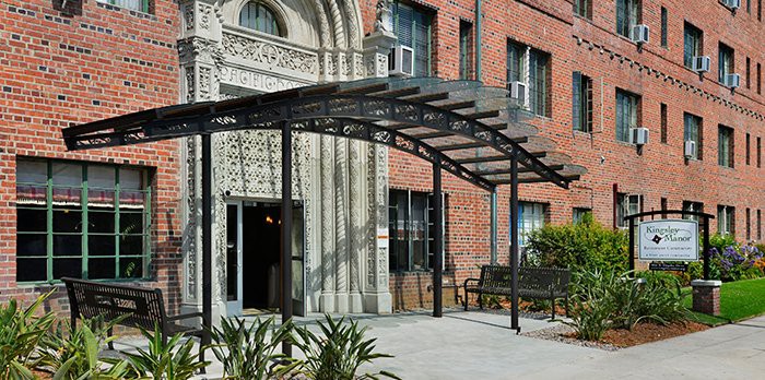 A building entrance with a decorative canopy and brick facade.