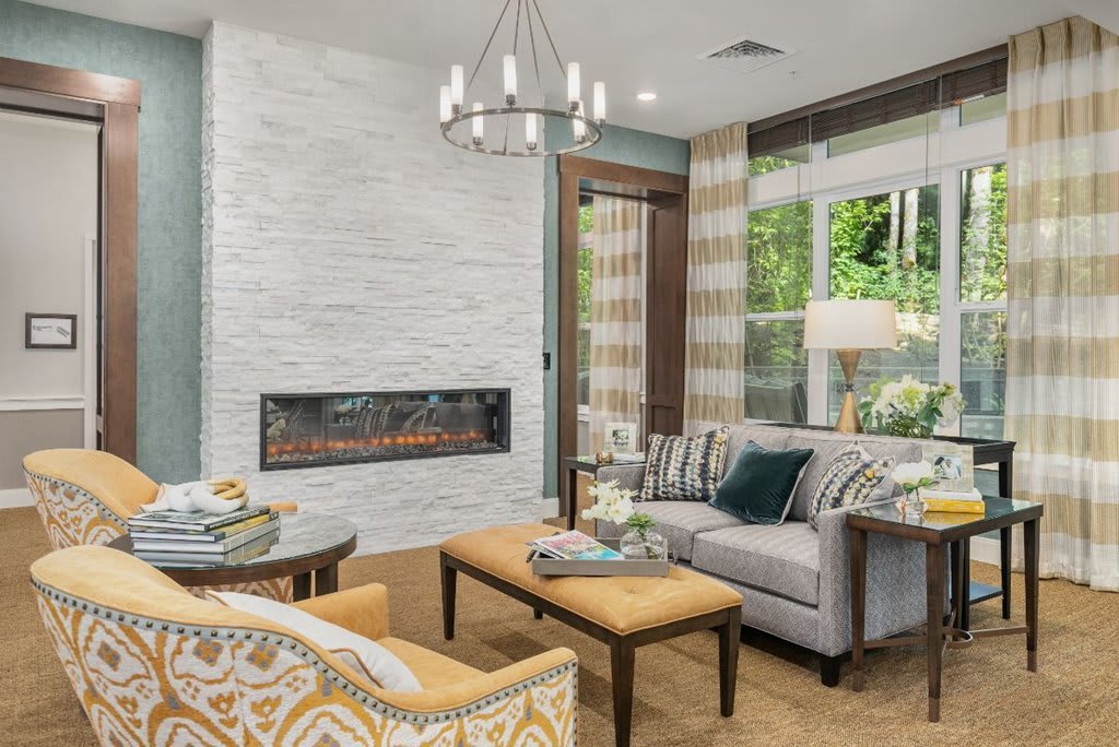 A stylish living room featuring a modern fireplace, elegant sofa, and chic chandelier.