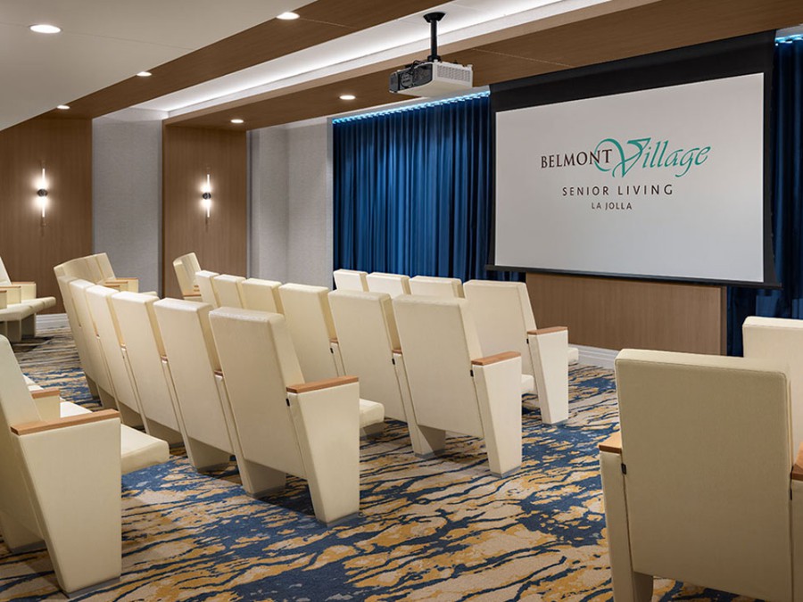 A modern theater room with comfortable seating and a projector screen.