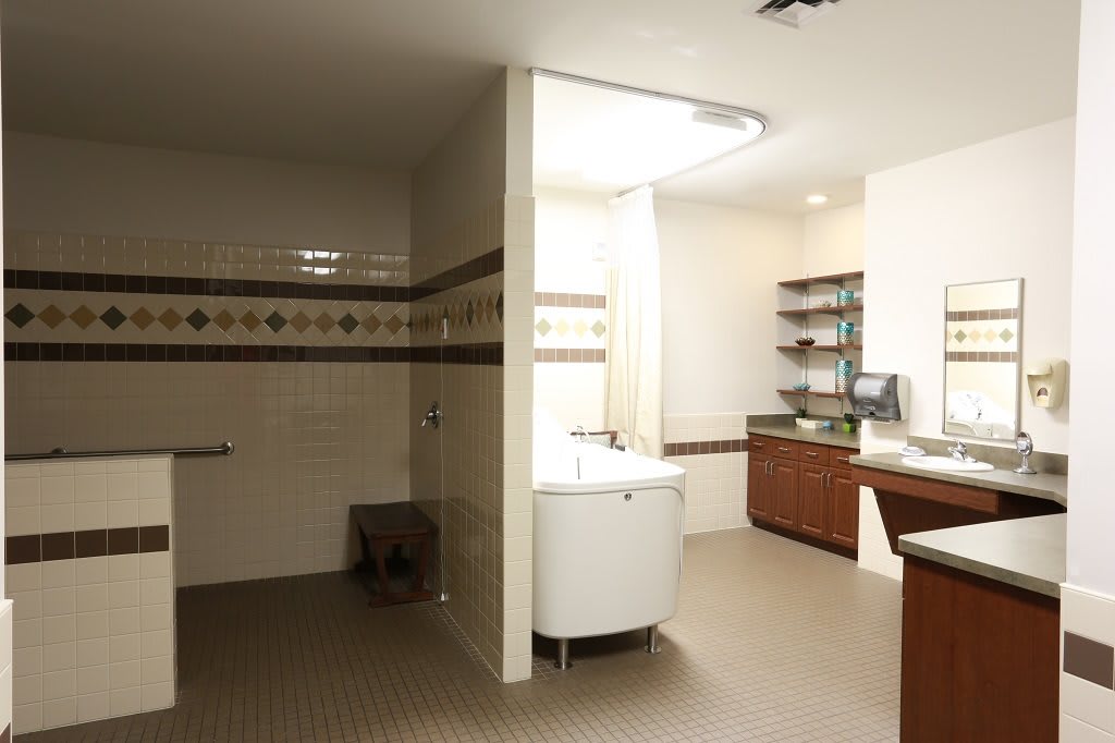 A modern bathroom interior featuring a sink, wooden cabinets, and well-designed lighting.