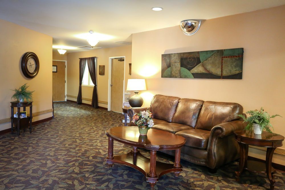 A cozy lobby area with a leather sofa, wooden table, and decorative elements.