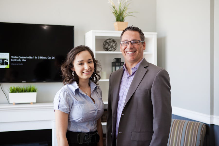 Two professionals smiling in an office setting.