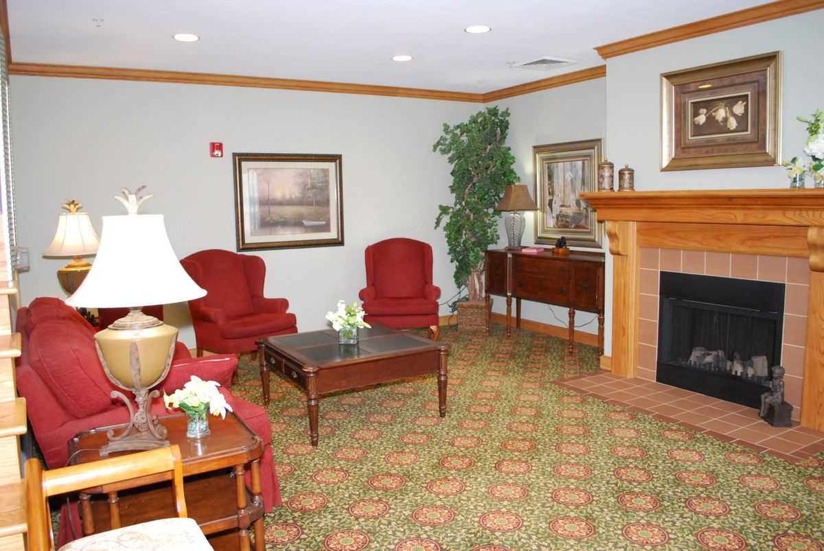 A cozy living room with red chairs and a fireplace.