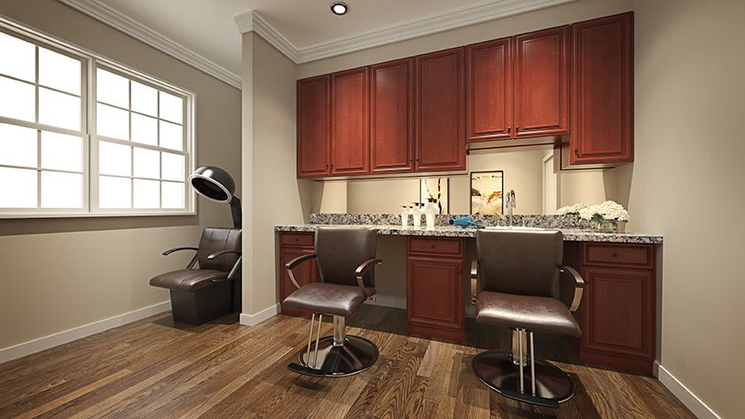 A cozy hair salon interior with two styling chairs, mirrors, and wooden cabinets.