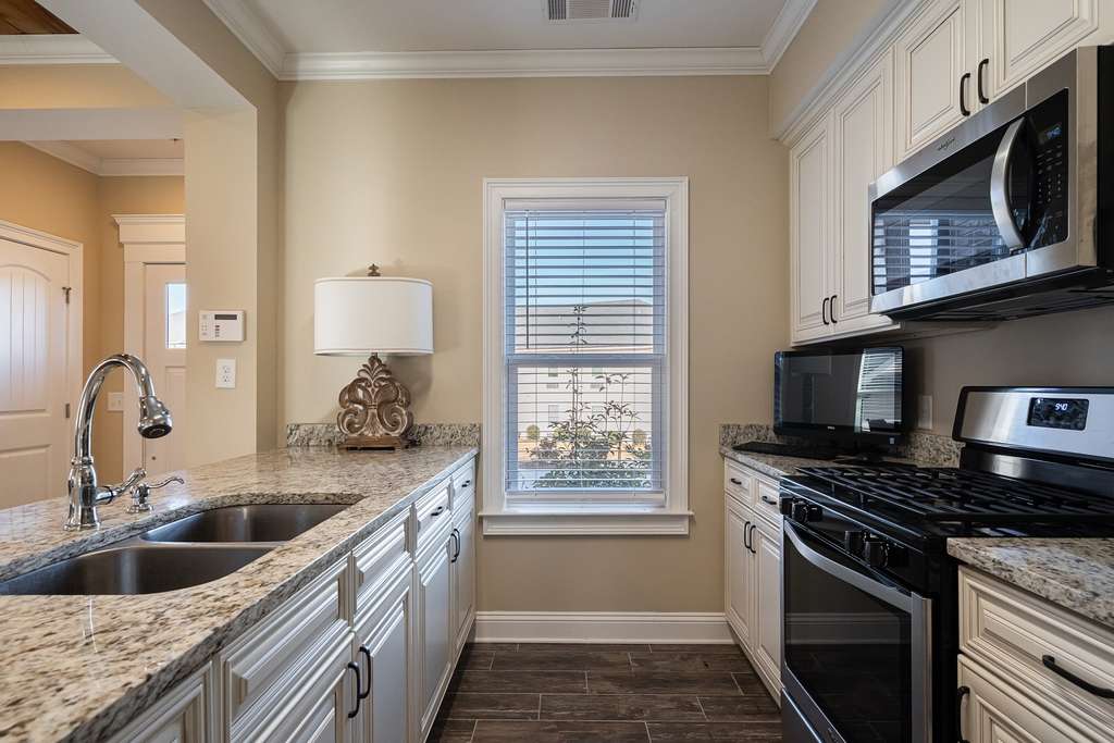 A modern kitchen interior with sleek appliances and a central window.