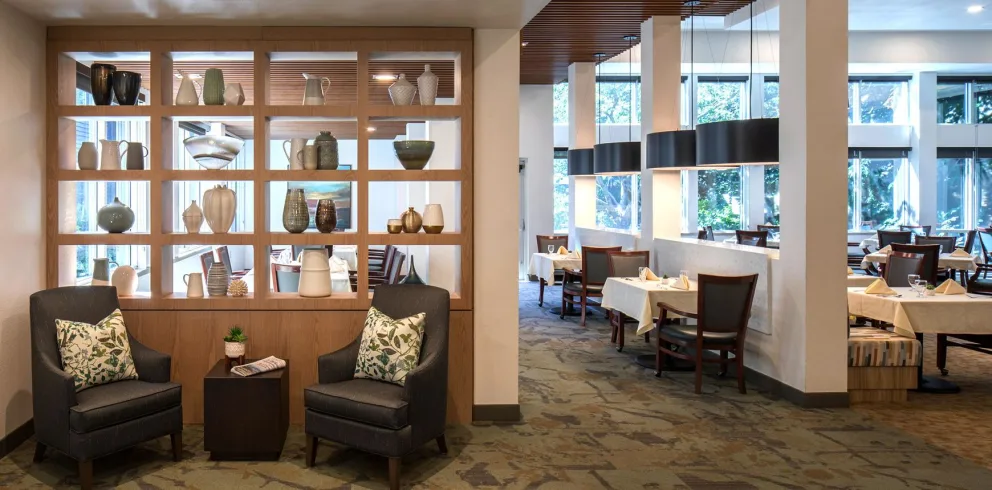 A modern restaurant interior with stylish decor, featuring a comfortable seating area and elegantly set dining tables.