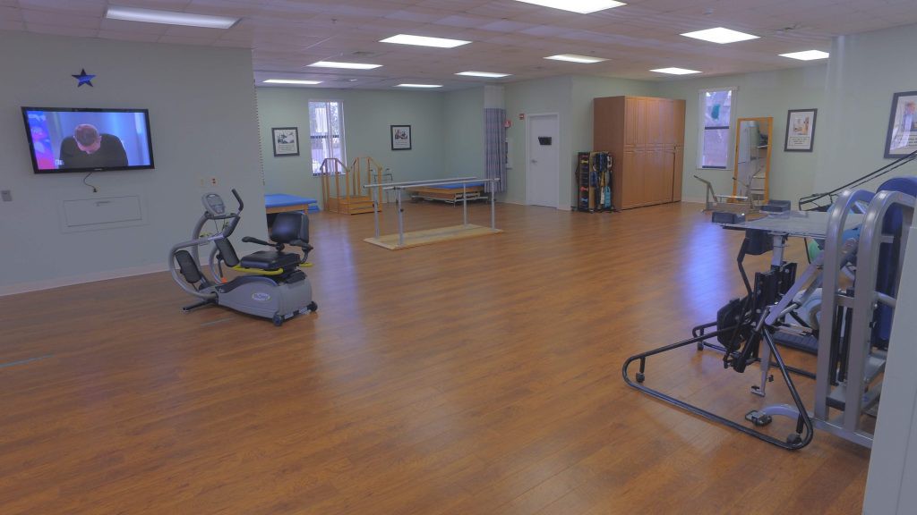 A spacious rehabilitation center with exercise equipment for physical therapy.