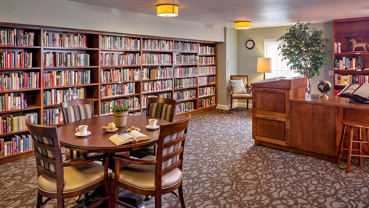 A cozy library room with bookshelves and a reading table.