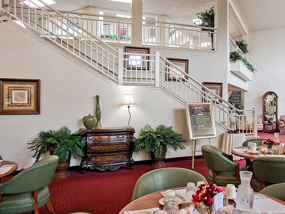 A cozy restaurant interior featuring elegant stairs and well-arranged dining tables.