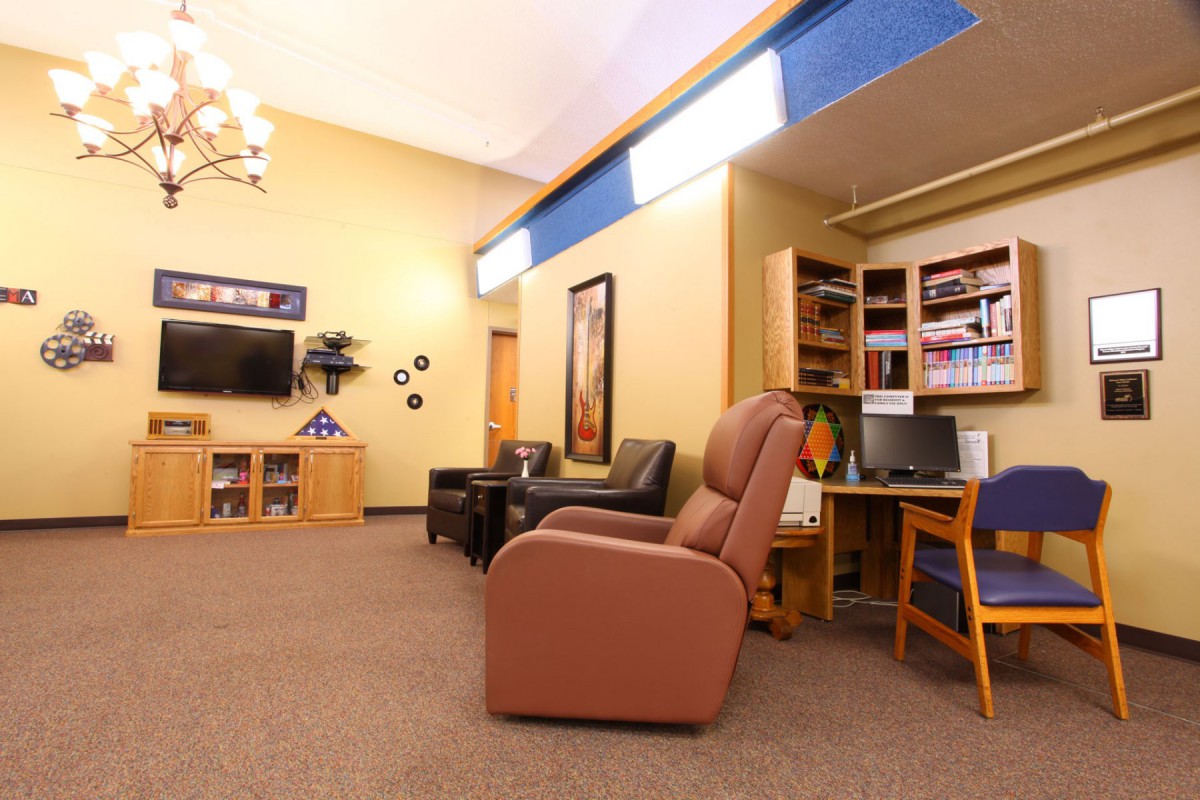 Cozy living room with comfortable seating, a television, and a well-stocked bookshelf.
