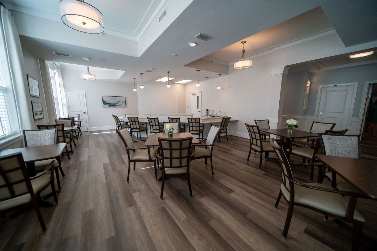 A modern dining room with elegant lighting and neatly arranged tables and chairs.