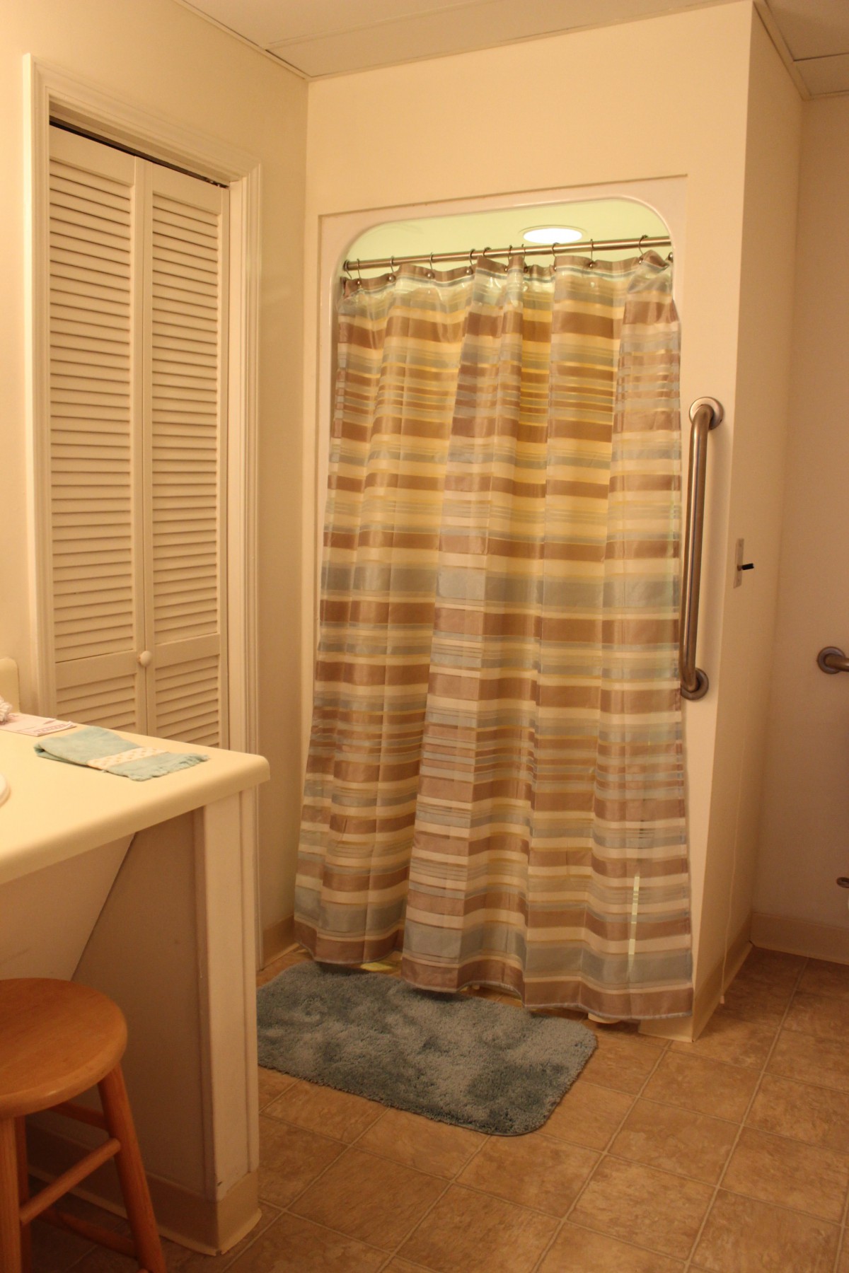 A cozy bathroom with a striped shower curtain and countertop sink.